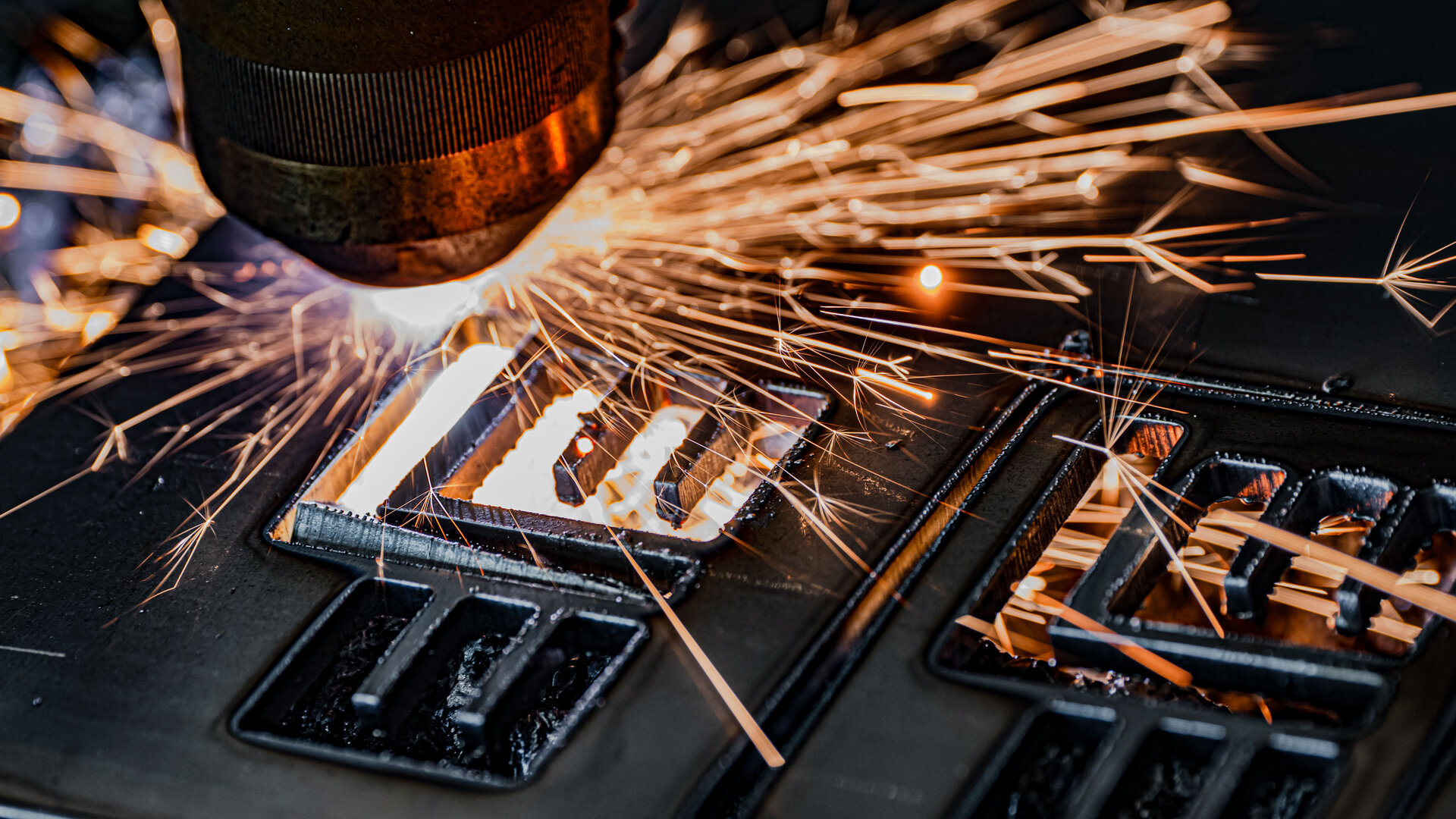 Ein präziser Laserstrahl schneidet durch Metall, während Funken in alle Richtungen sprühen und eine dynamische Szene erzeugen.