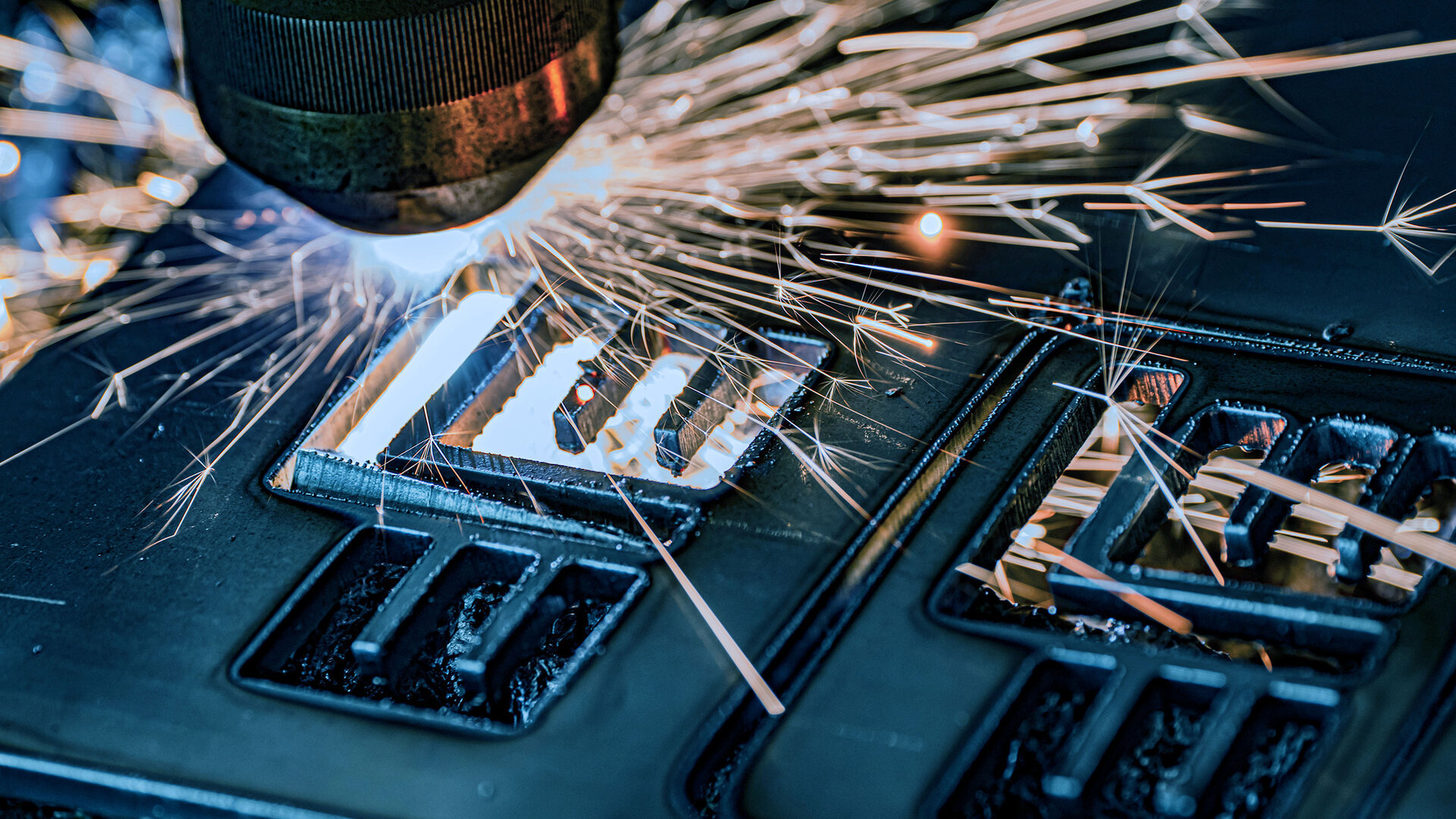 A precise laser beam cuts through metal, while sparks fly in all directions, creating a dynamic scene.